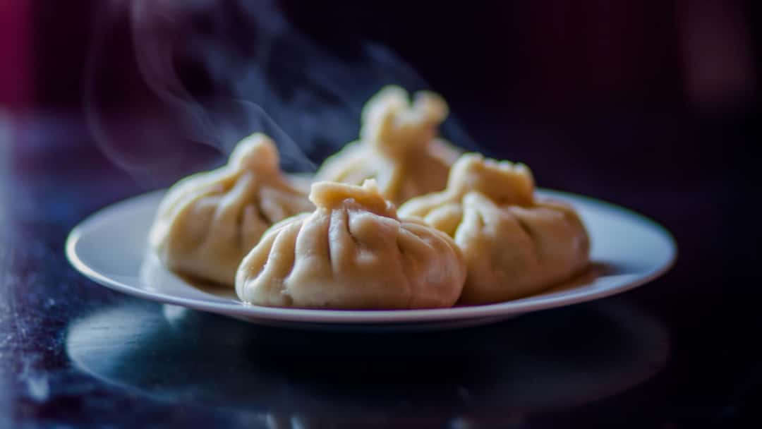 A plate of steaming momos on a plate