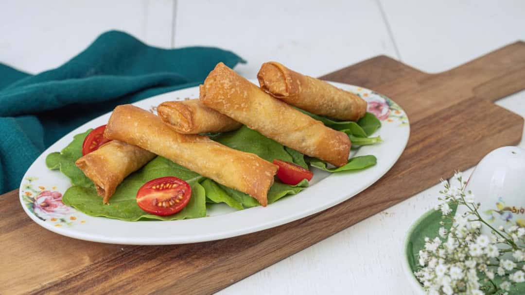 Crispy carrot and coconut spring rolls on an oval platter