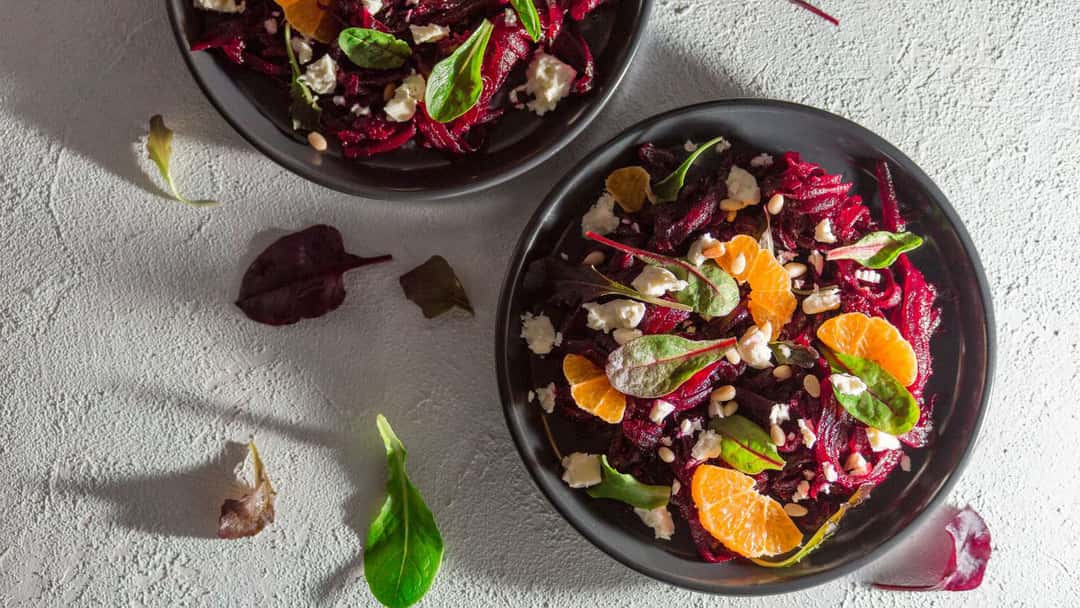 Beetroot and carrot salad in a black bowl - banner image