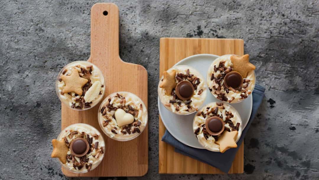 Top view of cheesecake pots on a wooden platter. (banner image)