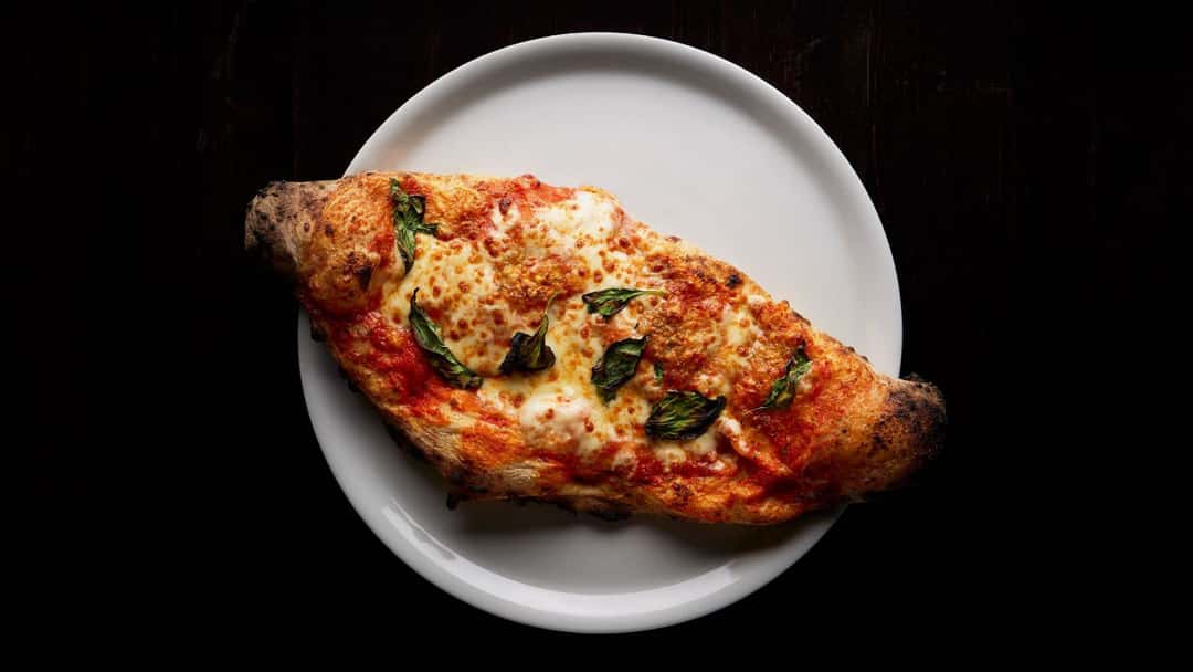 Top view of a calzone pocket on a plate. (banner image)