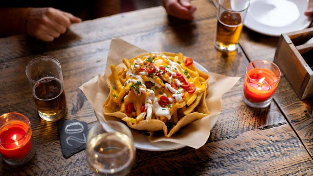 Top view of cheesy loaded fries in a bowl. (banner image)