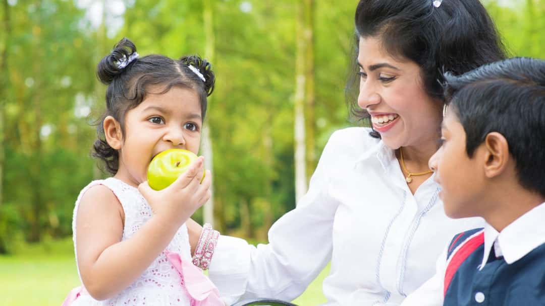 Child eating with mother and sibling.