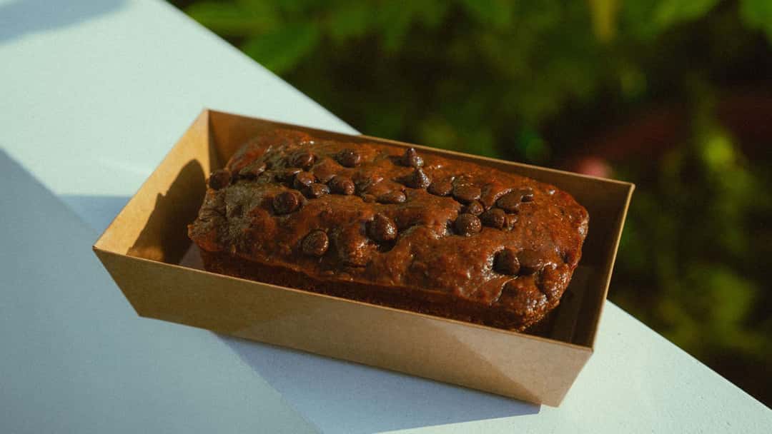 Chocolate zucchini bread in a paper dish. (banner image)