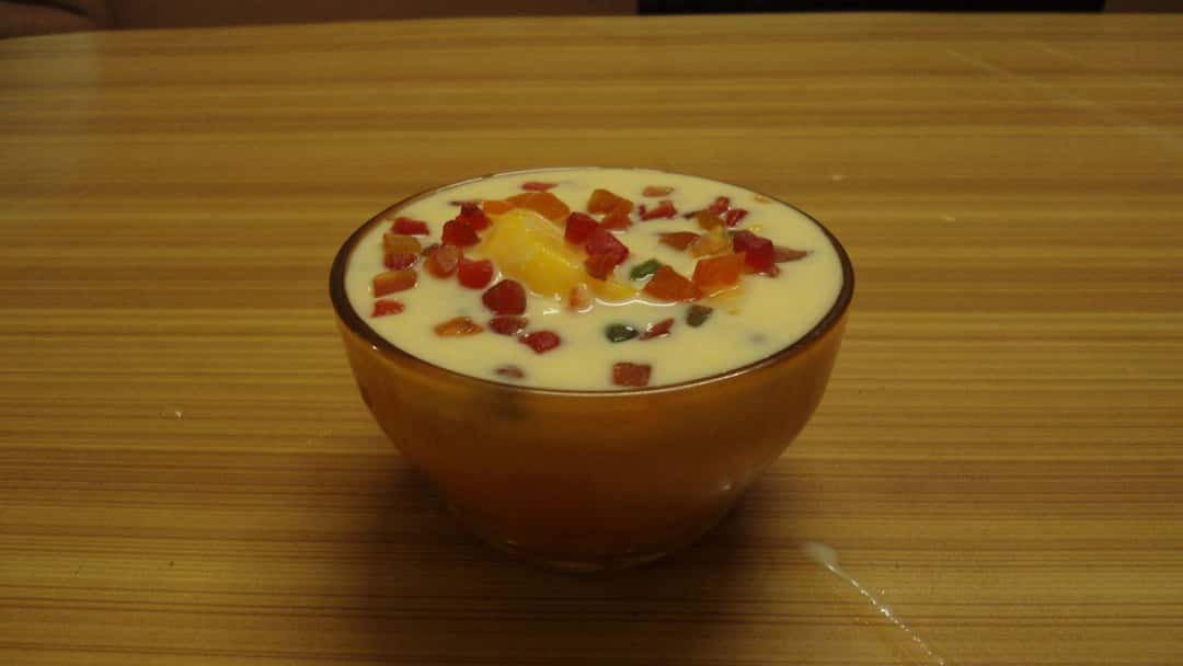 Bowl of fruit custard on table