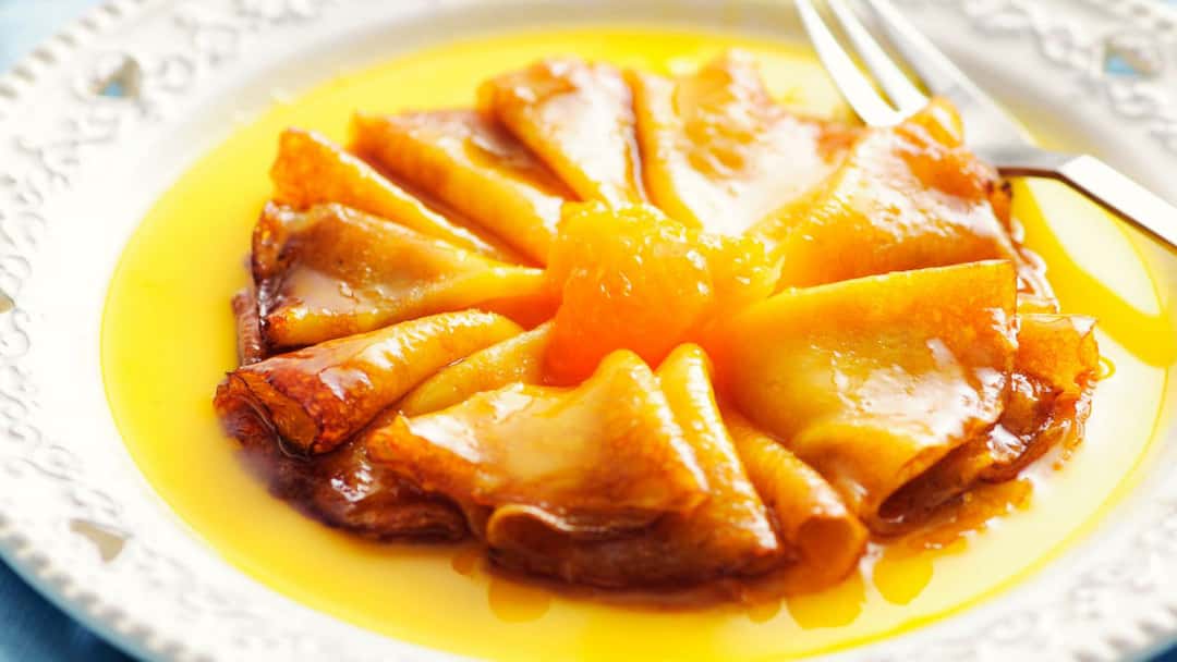 Top view of crêpe suzette on a plate. (banner image)