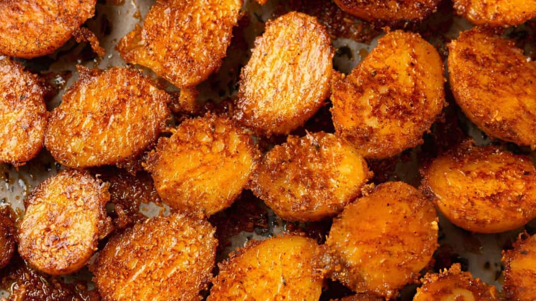 Golden crispy chewy potatoes on a tray. (banner image)