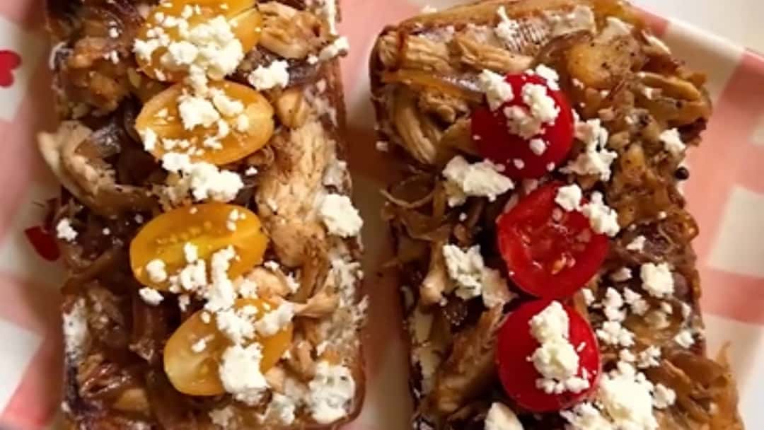 Caramelised onion chicken toast topped with cream cheese, cherry tomatoes, and feta