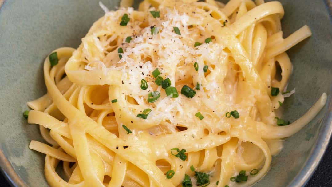 Spaghetti coated in creamy garlic butter sauce topped with Parmesan and parsley
