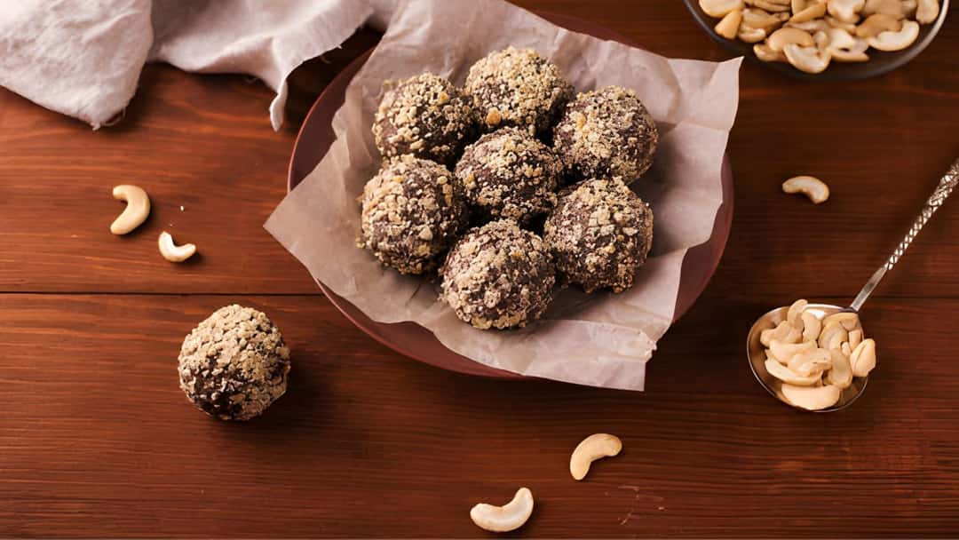 Kaju katli truffles on a plate lined with parchment paper
