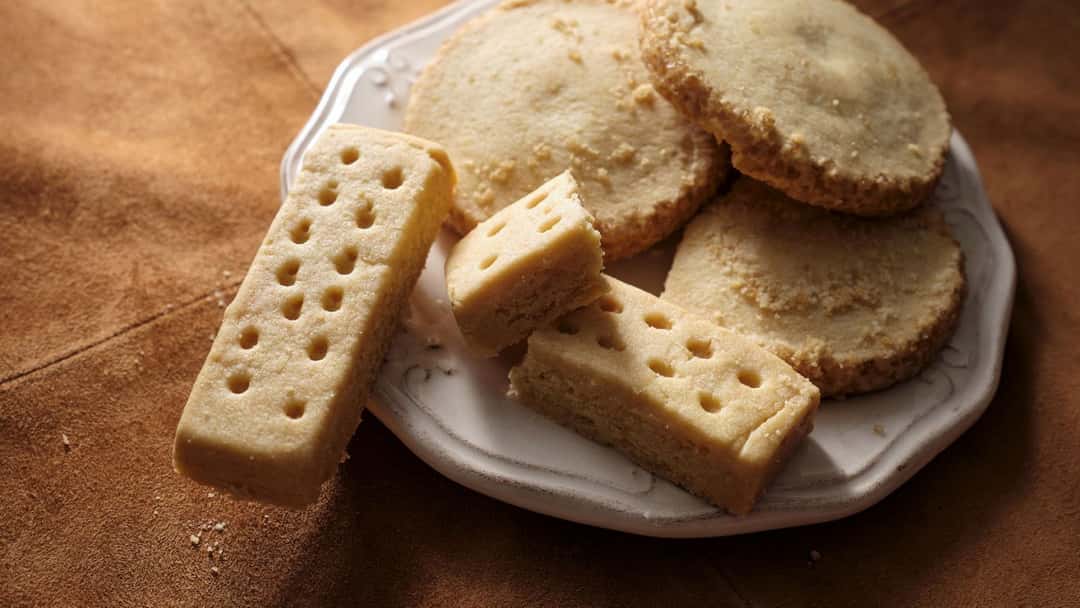 Top view of different-shaped shortbread cookies on a plate. (banner image)