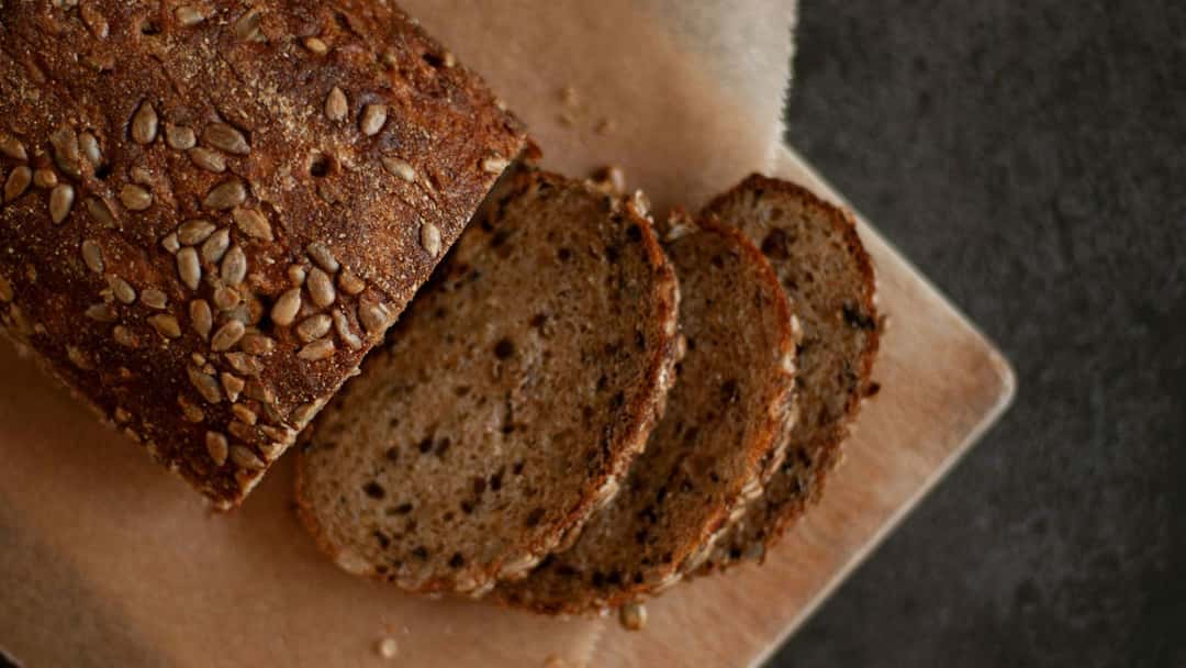 Top view of khapli wheat zucchini loaf on a wooden board. (banner image)