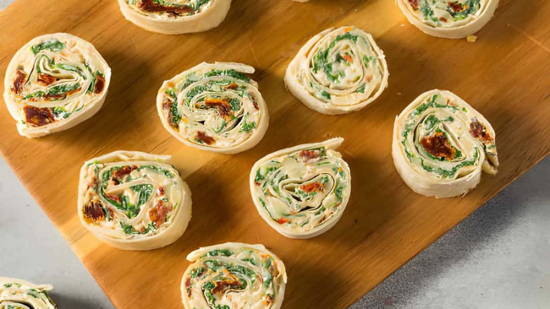 Mini tandoori paneer pinwheels on a wooden board