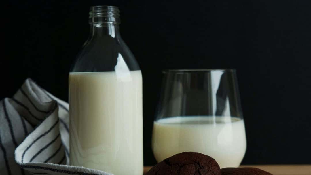 Milk bottle and glass with cookies.