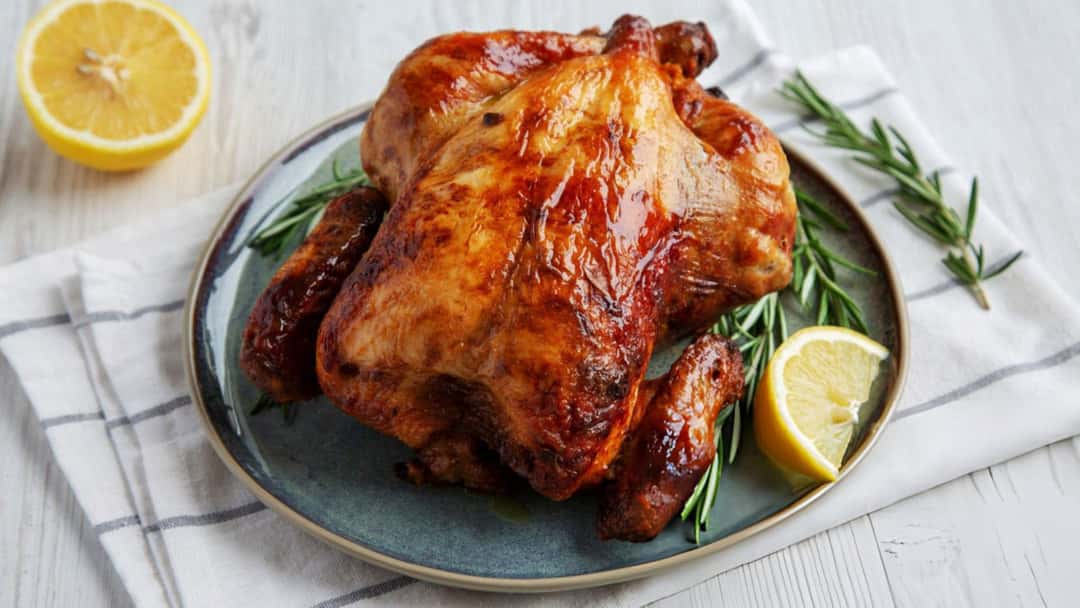 Golden brown miso butter roast chicken on a plate with herbs