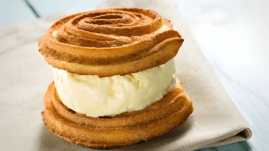 Churro ice cream sandwich on a surface lined with a kitchen towel