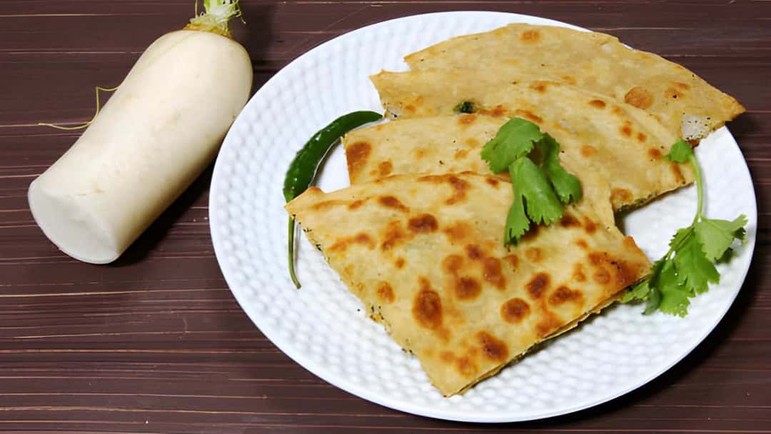 Mooli and dhania paratha slices placed overlapped on a white plate