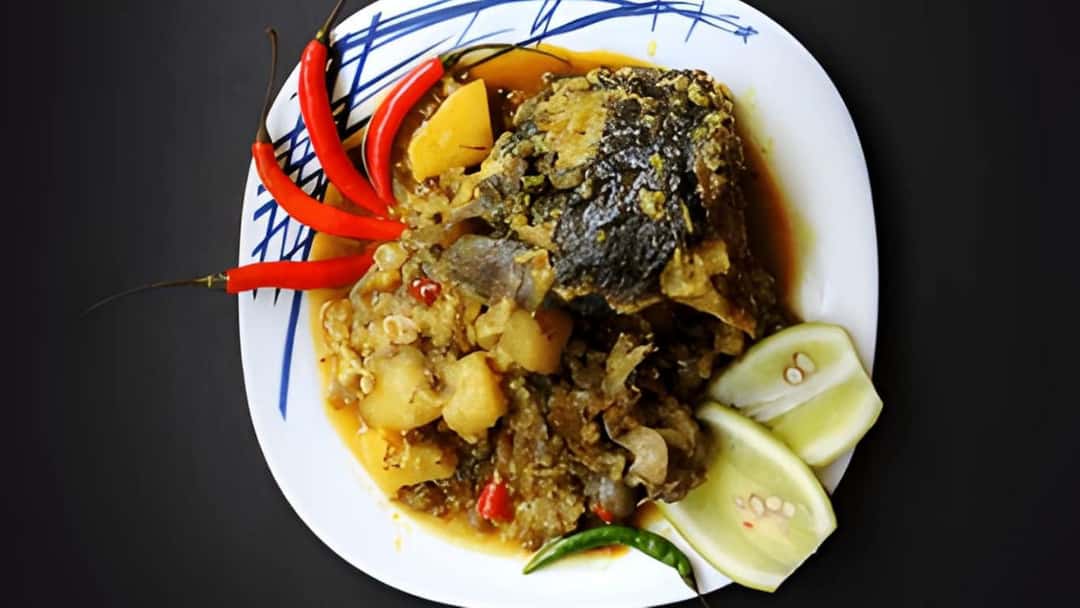 Close-up of muri ghonto with fish head pieces, rice, and cashews in a traditional Bengali preparation