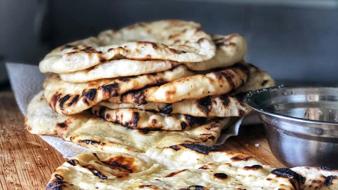 Naan resting on a cutting board.