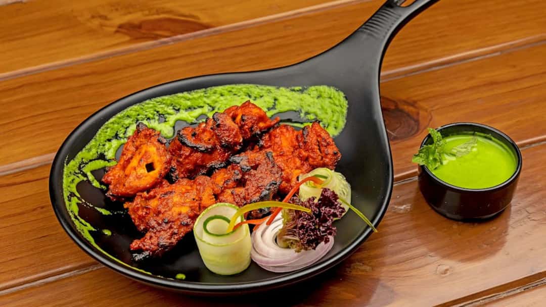 Tandoori chicken with green chutney on a plate
