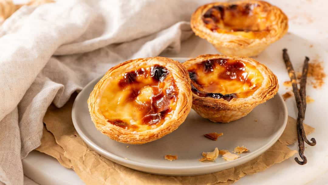 Top view of pastel de nata on a plate. (banner image)