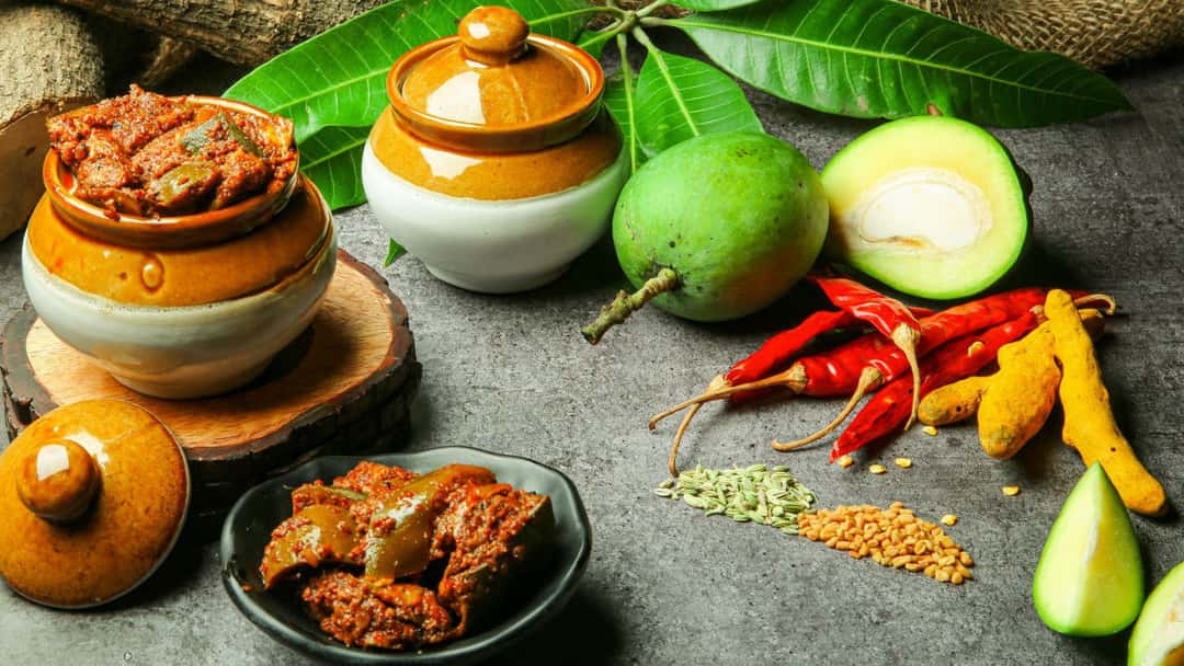 Aam ka achaar in a pot with ingredients