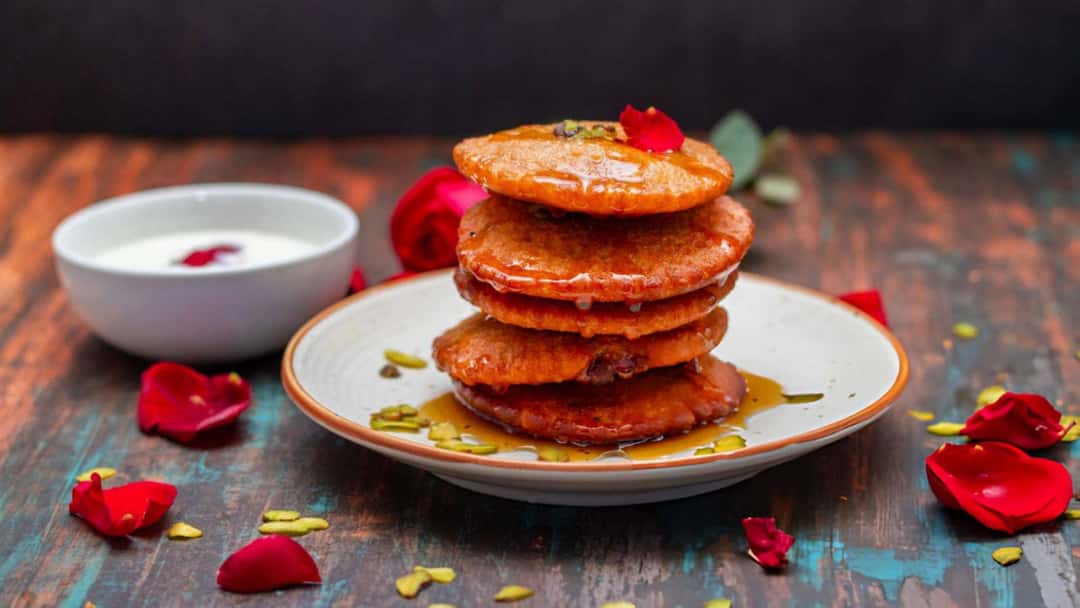 Sugar syrup-drenched malpua stack.