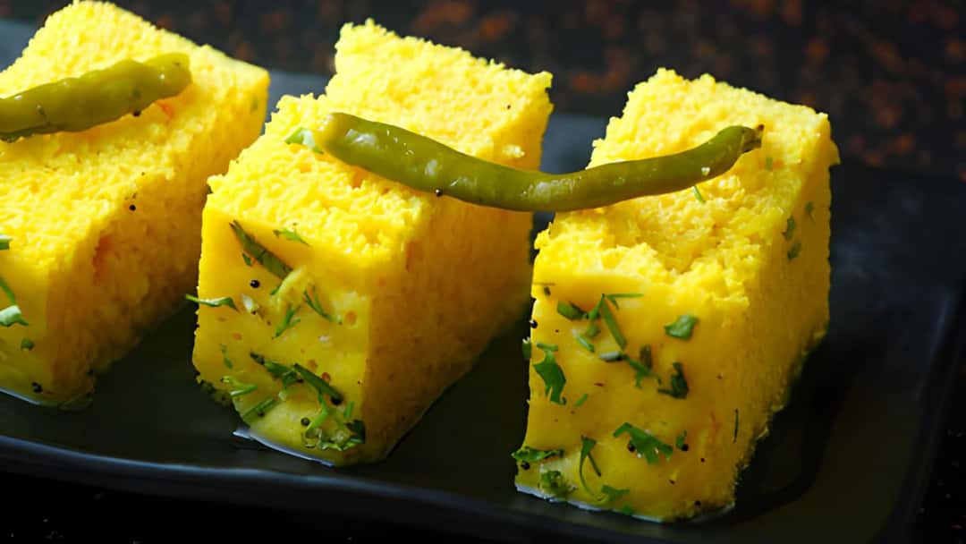 Steamed dhokla slices in a shallow bowl