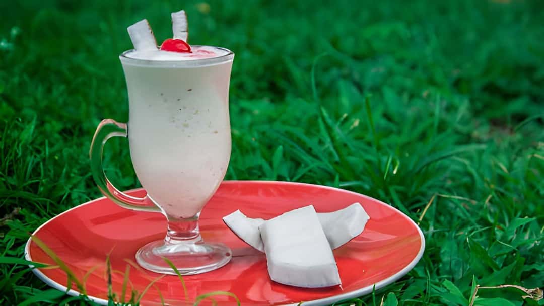 Top view of tender coconut malai shake on a plate. (banner image)