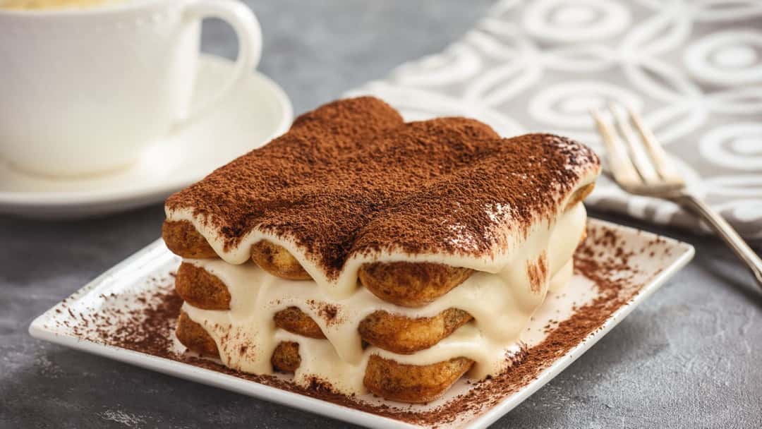 A close-up of tiramisu with a cup of masala chai. (banner image)
