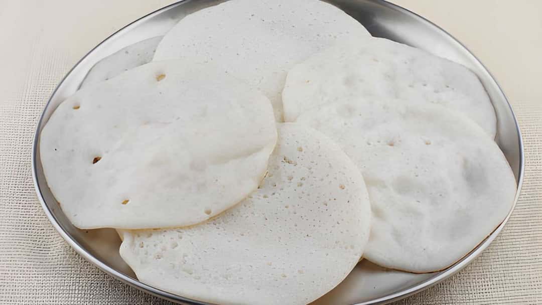 Vellayappams on a stainless-steel plate
