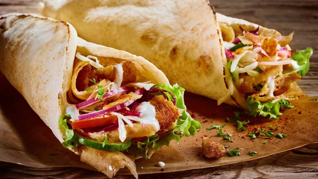 Side view of döner kebab wrap on a plate