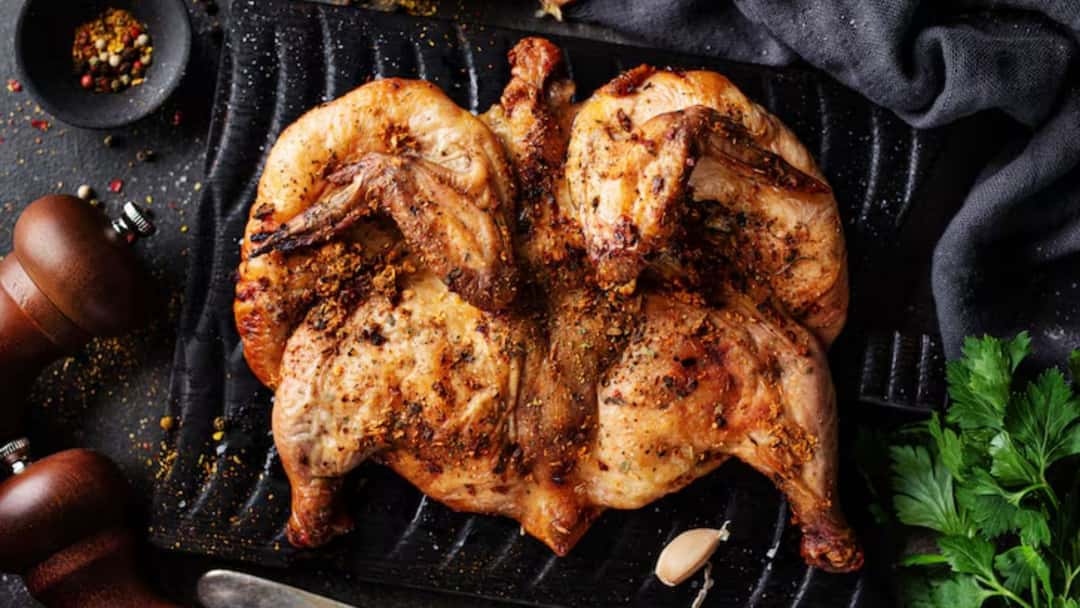 Smoky Al Faham grilled chicken served with flatbread, lemon wedges, and garlic sauce