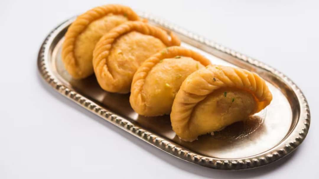 Golden fried Kesar Mawa Gujiya filled with khoya and dry fruits