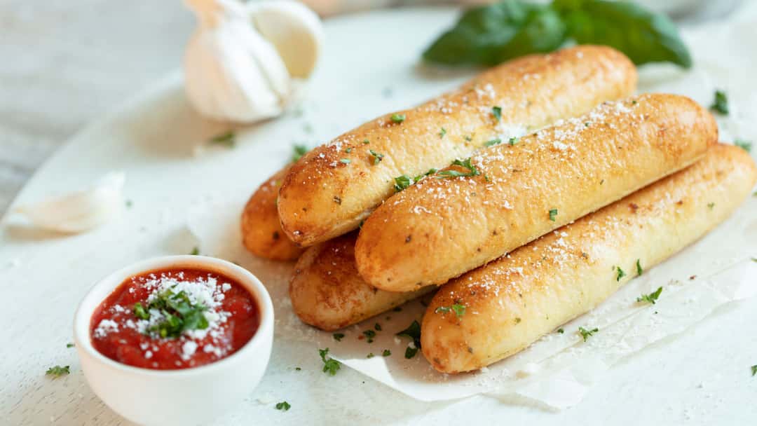 Freshly baked Khapli wheat garlic breadsticks brushed with garlic butter