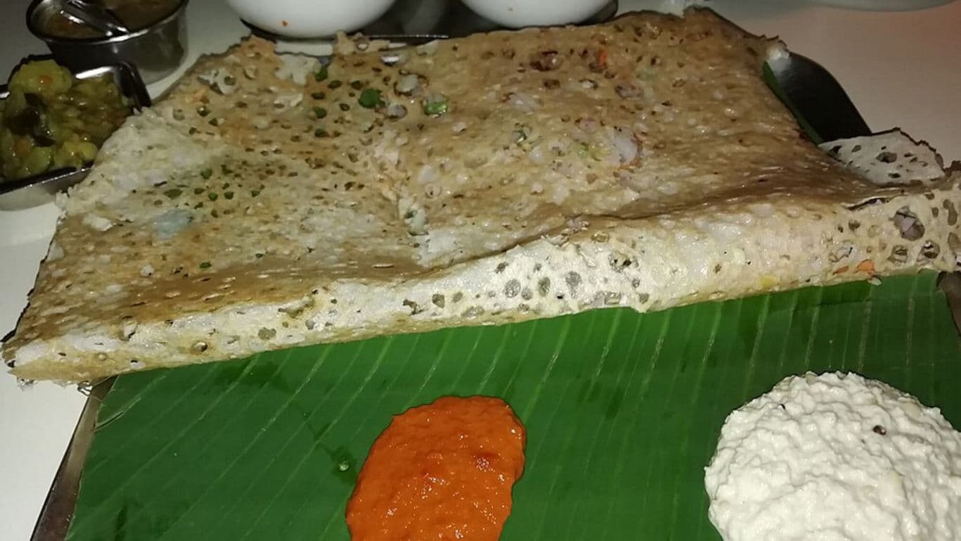 Crispy South Indian dosa with chutneys on banana leaf