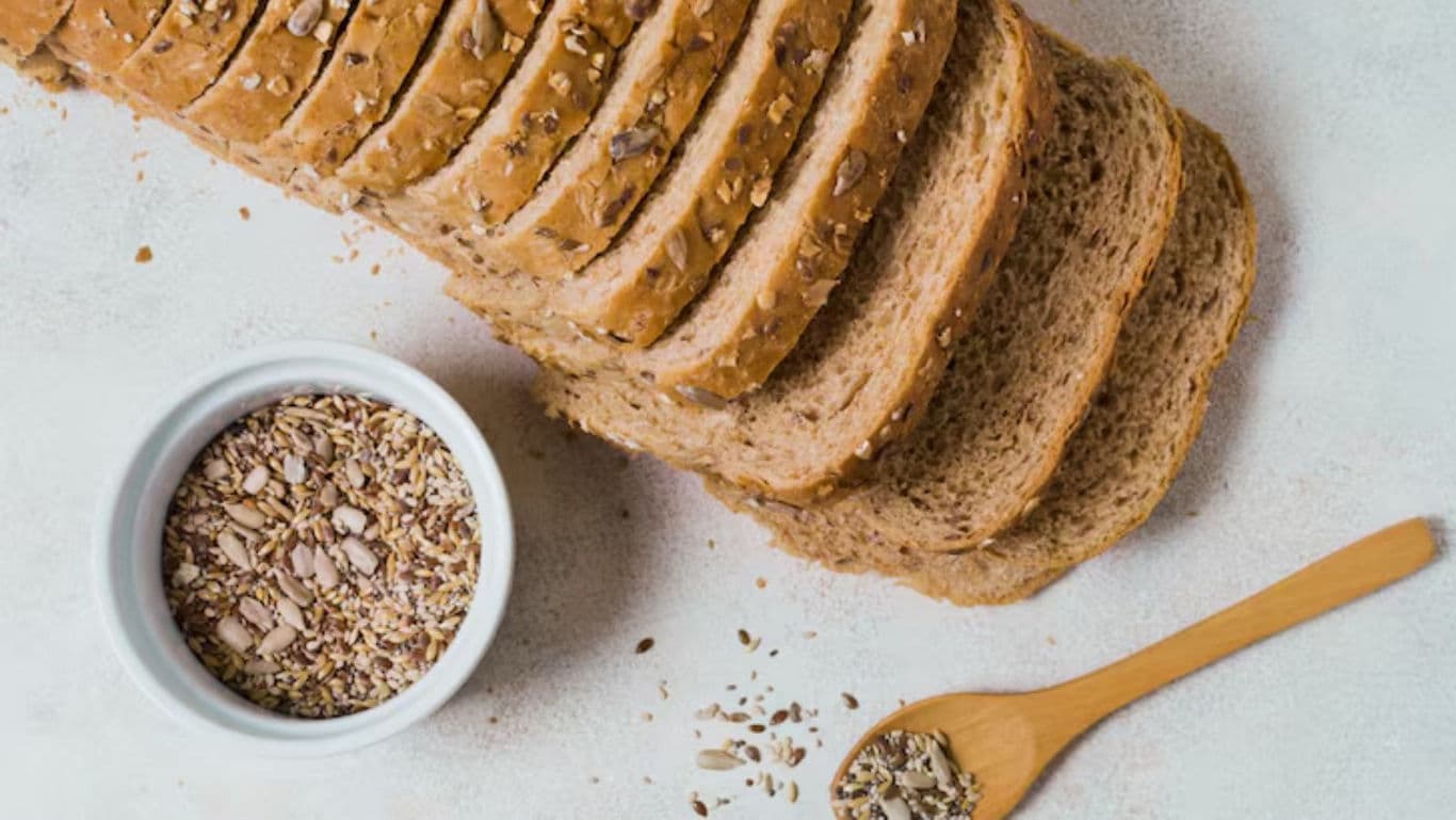 Sliced whole grain bread with seeds on table