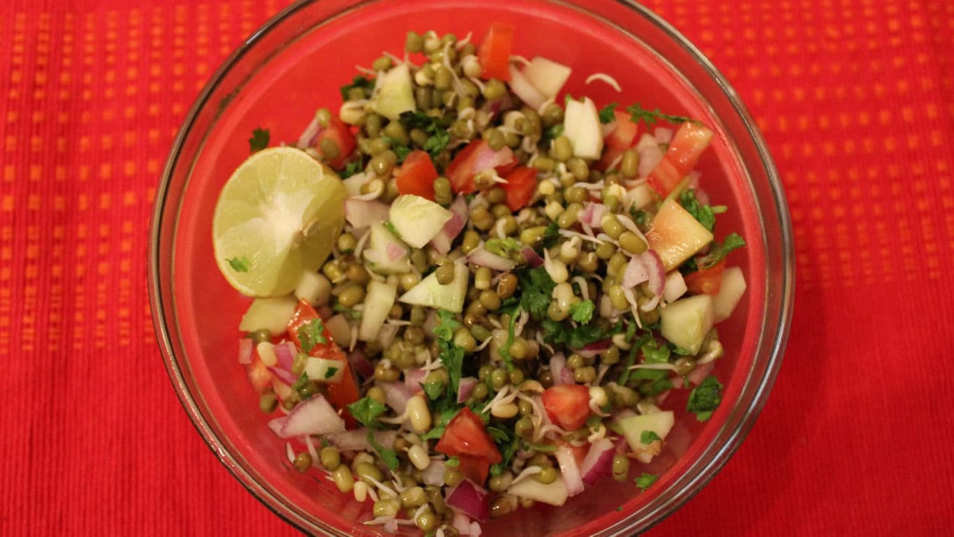 Fresh sprouted moong salad with vegetables and lime