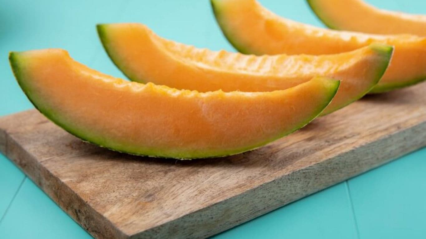 Fresh cantaloupe slices on wooden board