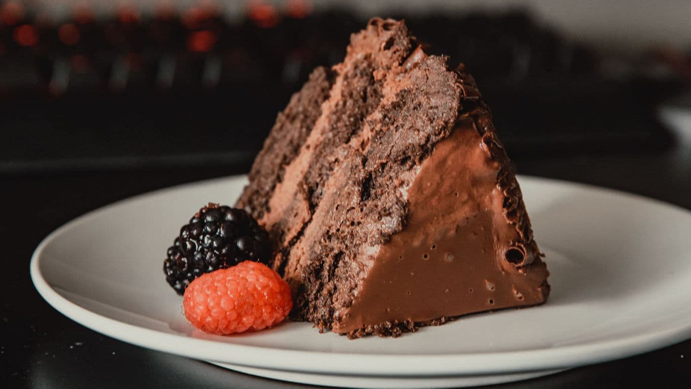 Chocolate Cake Slice Getting Lifted In A Spatula From The Whole Cake