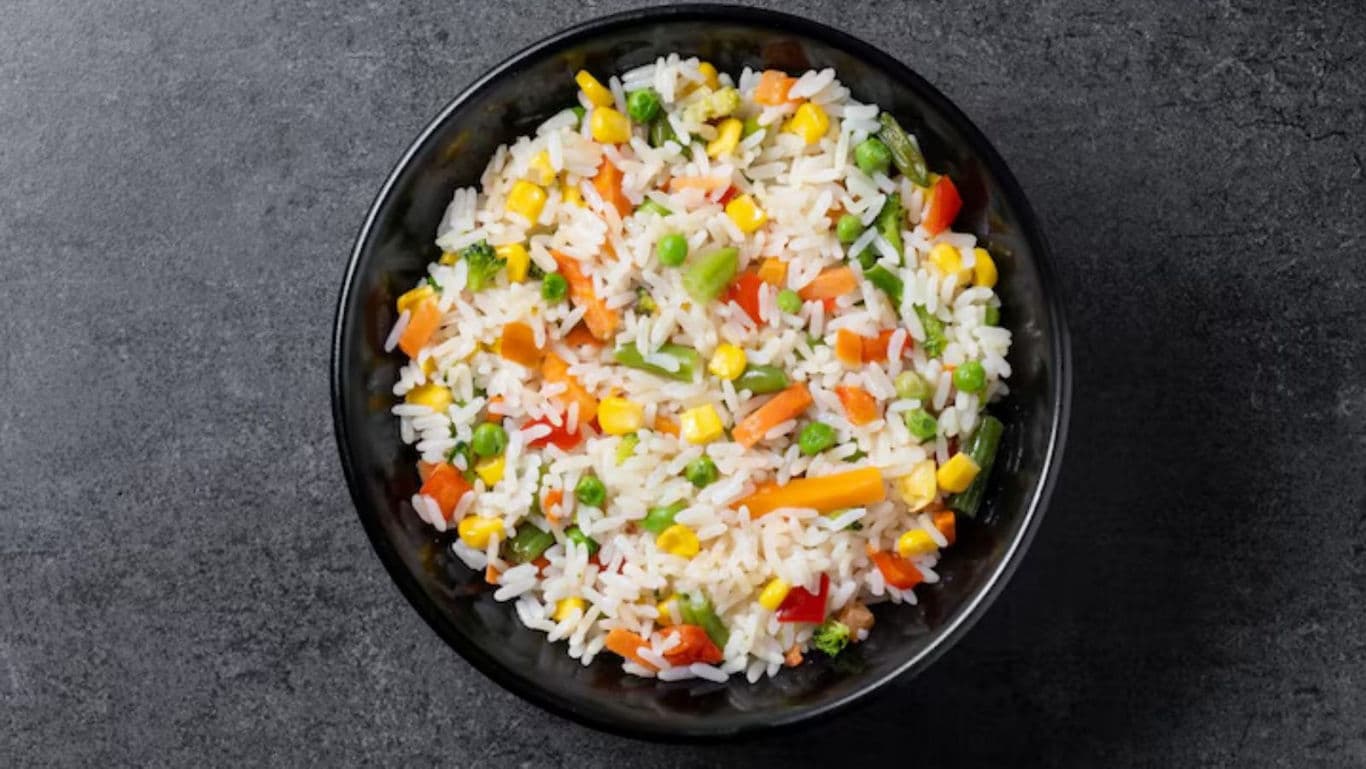 Colorful vegetable fried rice in black bowl overhead