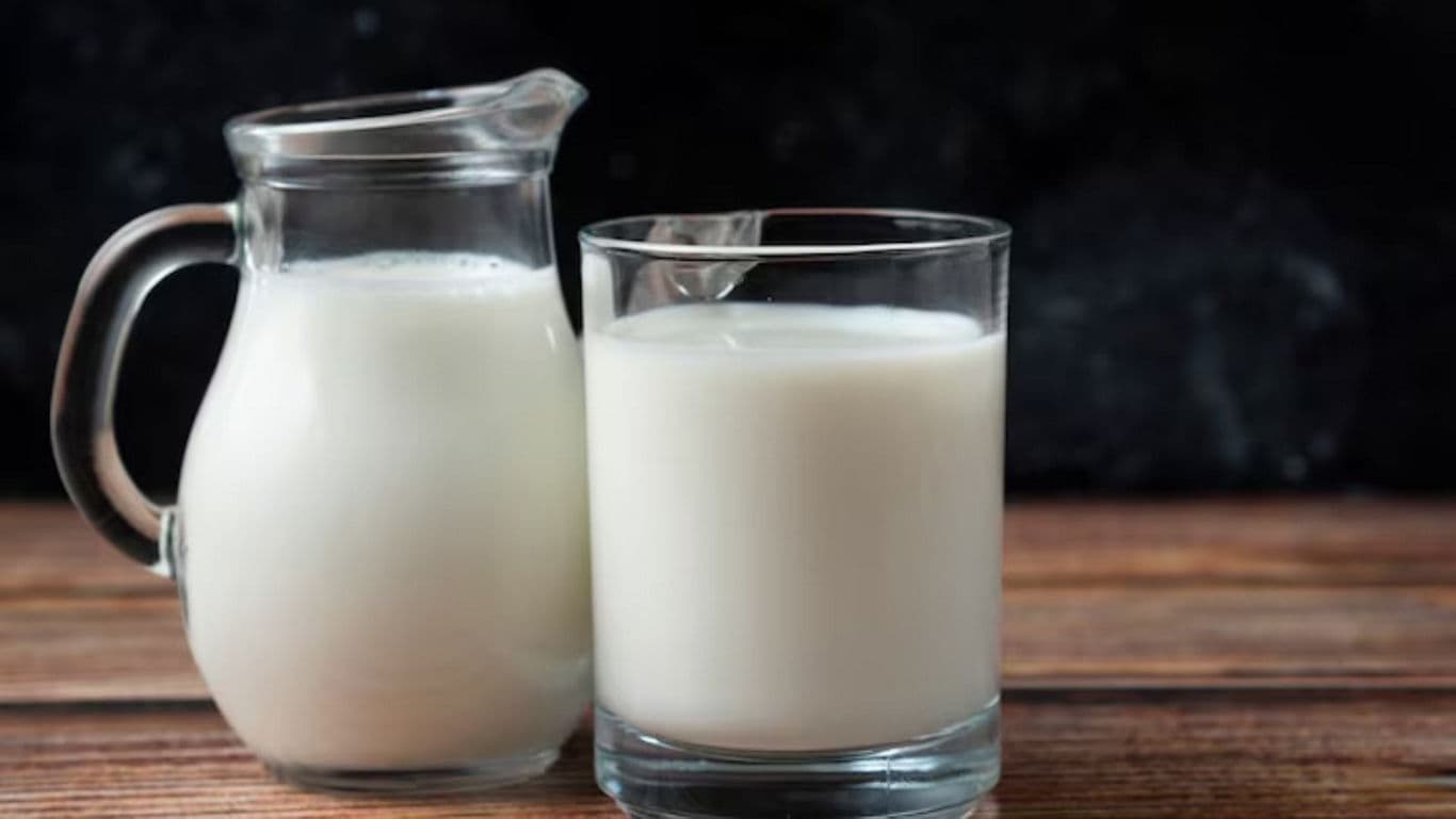 Glass and Jug of Fresh Milk on Wooden Table
