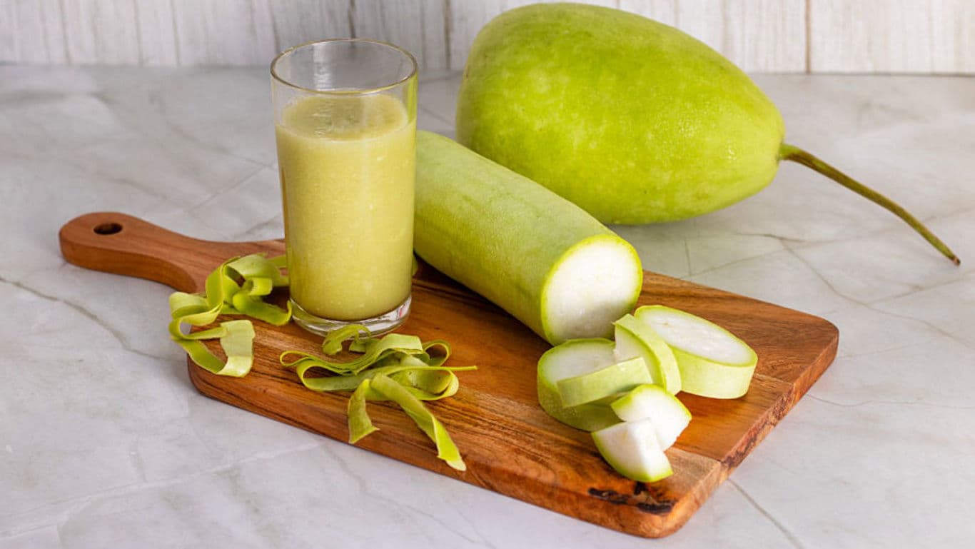Fresh bottle gourd juice and sliced gourd on board