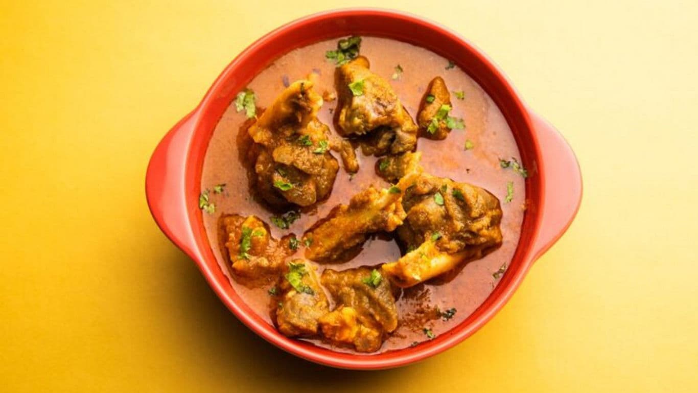 Spicy Mutton Curry in Red Bowl on Yellow Background