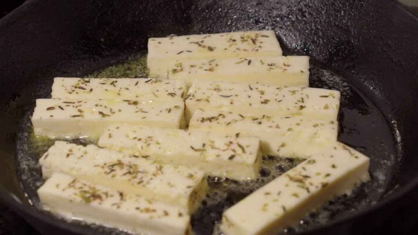 Herb-Seasoned Cheese Slices Cooking in Skillet