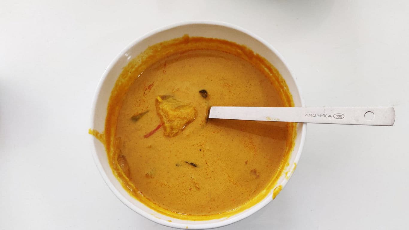 Bowl of creamy yellow curry with spoon