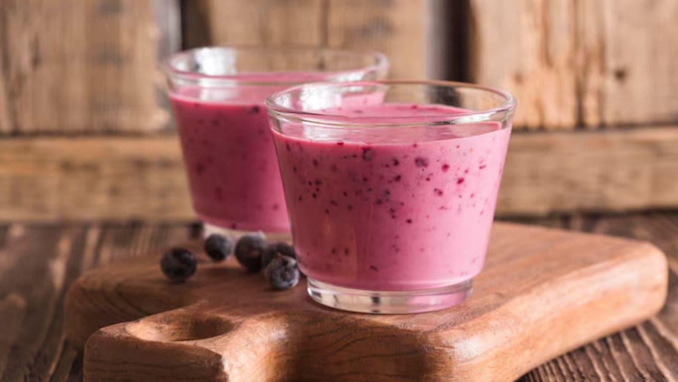Berry smoothie in glass cups on board