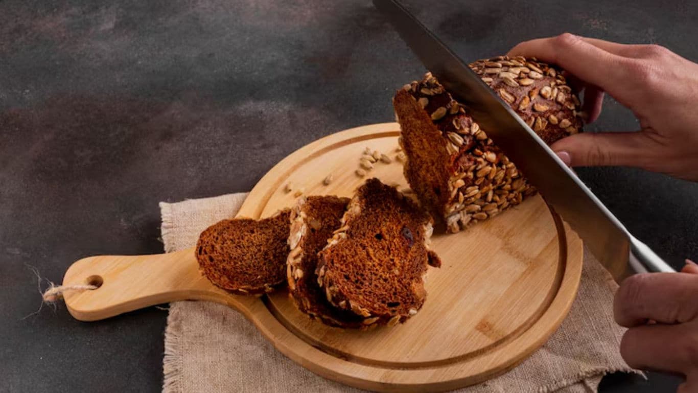 Sliced multigrain bread on wooden cutting board
