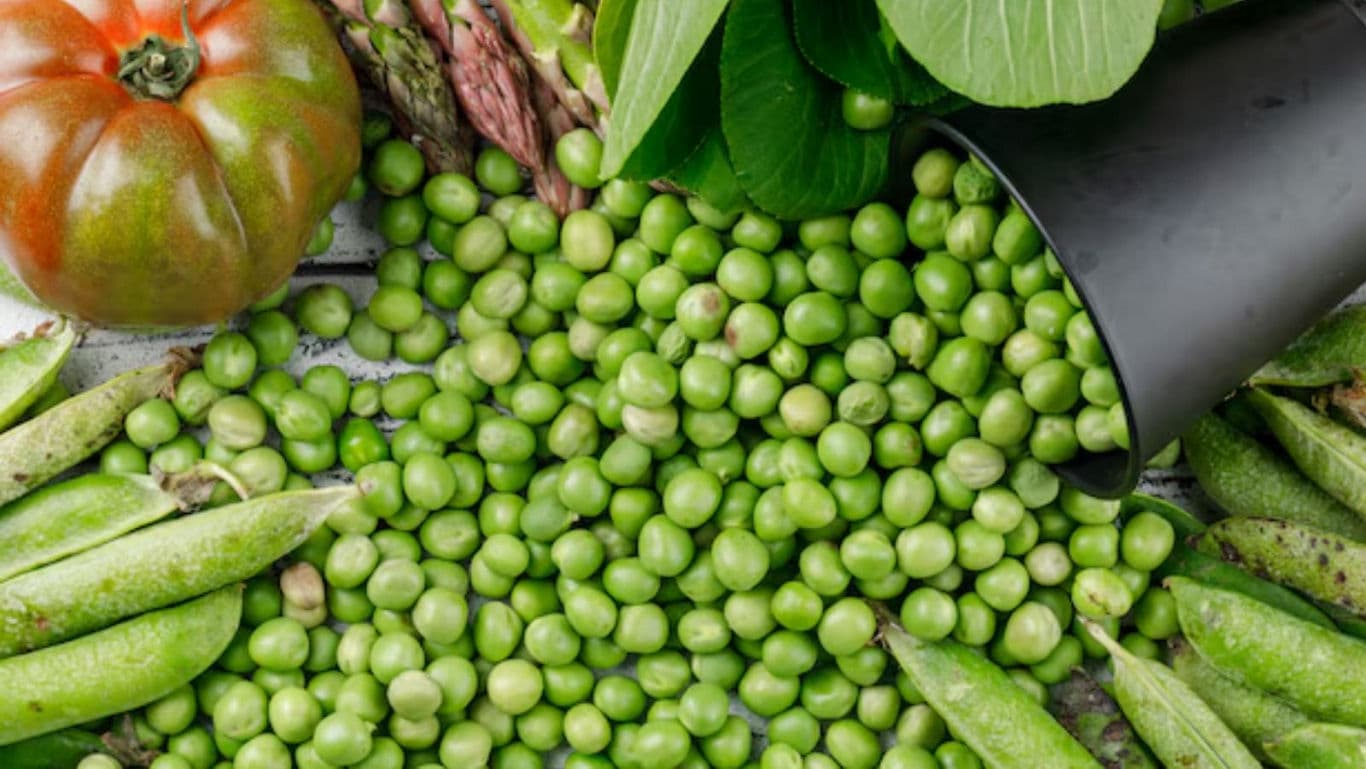 Fresh Green Peas and Vegetables on Tabletop