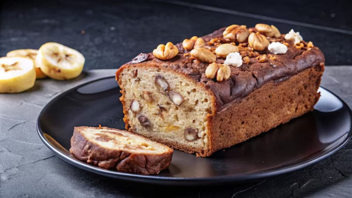 Nutty banana bread loaf on black plate
